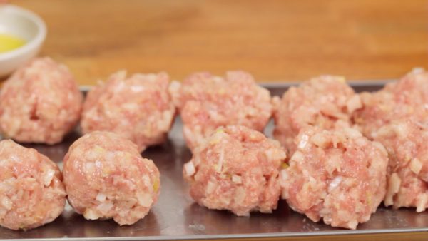 When the meat mixture is thoroughly combined, shape them into balls about the size of ping pong balls and place them onto a plate. You'll have about 12 meatballs in total.