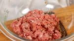 让我们把肉丸的原材料混合吧。把肉装在一个大碗里，用盐和胡椒粉调味。加入酱油和清酒。用手搅拌它们，使之混合在一起。