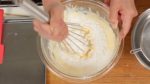 Peneire a farinha de bolo na tigela. Mexa a mistura até que não hajam mais pelotas de farinha.