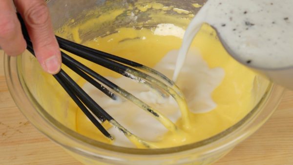 Add one-third of the milk to the bowl, diluting the egg yolk. Make sure to add the milk film and vanilla seeds. 