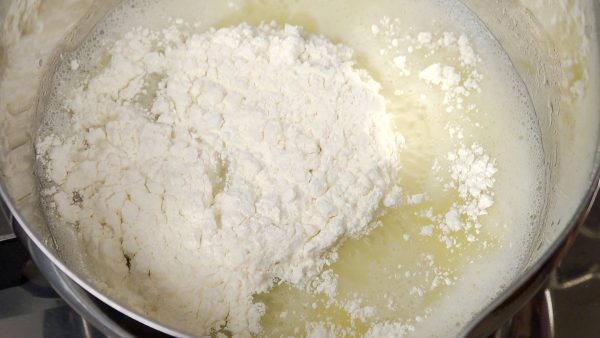 在鍋裡加入過篩好的低筋麵粉。快速攪拌混合物。