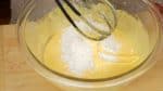 把低筋麵粉和玉米澱粉混合，然後過篩在一張紙上。把它加入打好的蛋黃，然後混合在一起。
