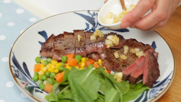 Placez le steak sur une assiette à côté des pousses d'épinard et un mélange de légumes cuits à l'eau. Saupoudrez avec des miettes d'ail frit. Versez dessus la sauce et savourez le délicieux steak ! 