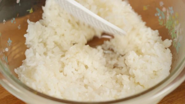 When the vinegar is distributed evenly, slightly cool the rice with a fan. Flip the rice over and continue to cool the rice. This will help give the rice a glossy texture and remove the excess moisture.