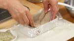 Phủ hộp dành cho cơm hộp bento bằng bọc nhựa và để shime saba (cá thu ướp) với mặt da hướng xuống.