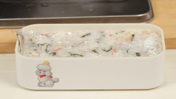 Mouillez la spatule et placez du riz dans la boite à bento à nouveau. Étalez bien. Couvrez et pressez à nouveau. Laissez reposer le sushi au frigo environ 10 minutes, pour permettre aux ingrédients de bien attacher ensemble. 
