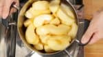 Quand le sucre fondu commence à faire un son de mijotage, retirez le couvercle et remuez la casserole pour faire remonter les pommes du dessous sur le dessus. Cette méthode va éviter de casser les pommes. De temps en temps mélangez les pommes depuis le fond avec une spatule en bois. 