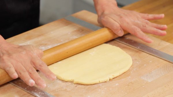 Roll out the dough from the middle outwards. Then, roll it out from the middle towards you. Rotate the dough 90 degrees and repeat the rolling process. If it sticks, dust the dough and rolling pin and quickly roll it out. The circle should be about 27cm (10.6") in diameter and 3mm (0.1") thick.