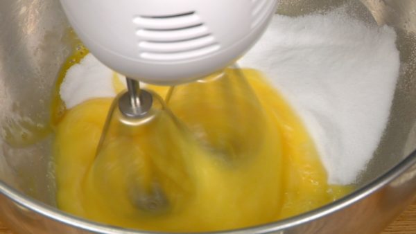 Cassez les œufs dans un grand saladier et battez-les avec un fouet électrique à basse vitesse. Ajoutez le sucre en une fois et battez le mélange pour environ 30 secondes. 