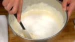 Troque o batedor por um fouet e mexa o ovo uniformemente. Coloque a farinha de trigo na tigela. Misture delicadamente a farinha que está fundo da tigela com uma espátula de silicone. Tente não desfazer a espuma e mexa do fundo da tigela até a superfície por aproximadamente 30 vezes.
