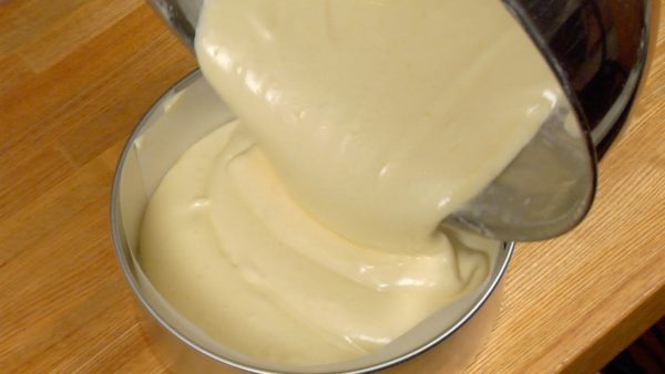 Quand la pâte devient brillante et lisse, versez-la dans le moule à cake. Tapez le moule quelques fois contre le plan de travail pour casser les grosses bulles d'air dans la pâte. 
