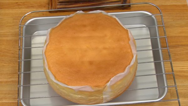 Tapez le moule quelques fois sur le plan de travail pour éviter que le gâteau ne s'affaisse. Couvrez le gâteau avec du papier cuisson, retournez-le et laissez-le refroidir sur une grille. Quand il a complètement refroidi, retirez le moule. Retournez la génoise et retirez le papier cuisson. 