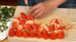 Let's prepare the soaking syrup. Dissolve the sugar in the hot water and cool it down. Select 8 good-looking strawberries for topping and remove the stem ends. The rest of the strawberries will go between the cake slices. Remove the stem ends and slice them lengthwise into half inch slices.