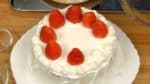 Levez le gâteau et placez-le sur le plat. Placez les fraises sur les ronds de crème. 