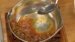 用長柄湯勺快速地分二至三次加入熱水。 注意鍋子要向外傾斜，避免滾燙的焦糖漿濺到手而燙傷。