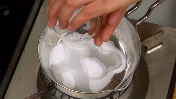 Pon azúcar y agua en una olla. Calentarla a temperatura media.