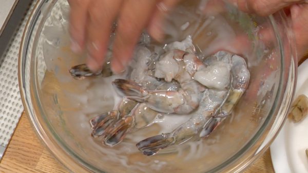 Put the prawns in a bowl. Add a pinch of salt, potato starch and a little water to it. Gently rub the prawns with the salt and starch. Take the bowl to the sink and rinse them with running water to remove the dirt and fishy smell.