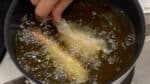 Faites frire les crevettes. Plongez un peu de chapelure dans l'huile chaude pour vérifier que la température de l'huile est à environ 175°C (347°F). Vous pouvez utiliser moins de 2 cm (0.8 inch) d'huile de friture pour cette recette. Retirez la chapelure sur la queue. Tenez les crevettes par la queue et placez-les doucement dans l'huile une par une. 