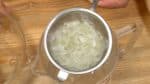 Coupez l'oignon en tranches fines, empilez les tranches les unes sur les autres et hachez-les finement. Versez l'oignon haché dans un autre bol et malaxez avec un peu de sel. Rincez l'oignon sous l'eau froide et égouttez dans une passoire fine. Essorez l'eau, mettez-les dans de l'essuie-tout et retirez l'excès d'eau. Ajoutez l'oignon à l’œuf haché. 