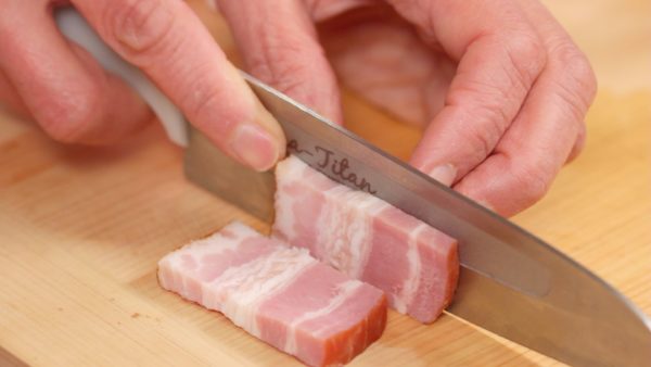 Snij het spek in vierkante plakjes van 7mm. Dit is een stuk vlees uit de buik van het varken, ook wel bekend als buikspek. 