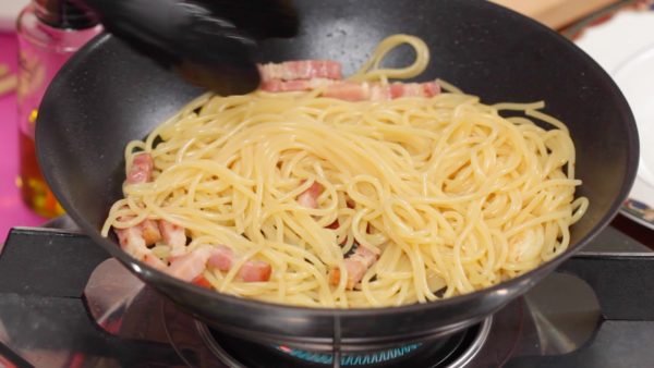 Ora, la pasta è pronta. Usando delle pinze mettetela nella padella. Spegnete il fuoco della pentola e riscaldate di nuovo la padella. Fate saltare la pasta in modo da ricoprirla bene con la salsa. 