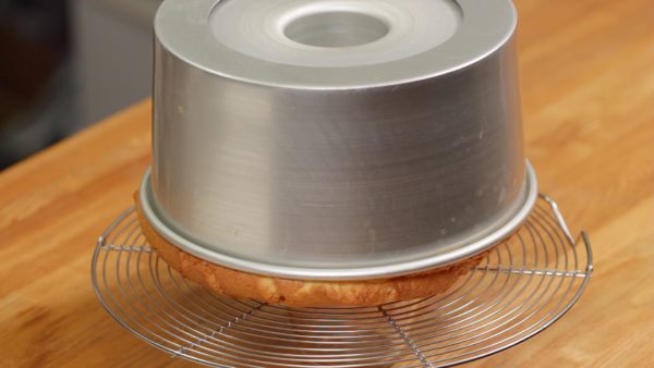 Remove the cake pan from the oven. Flip the cake over and place it onto a cooling rack. Chiffon cake is a relatively tall cake so cool it upside down to keep it from shrinking due to the weight.