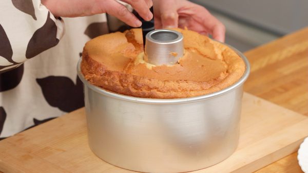 The chiffon cake is completely cooled. Insert an icing spatula between the cake and the pan. Slide the spatula along the edge.