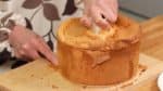 用抹刀沿著模具底部分開蛋糕。再把蛋糕翻過啦，小心地把模具底部拿下來。