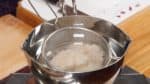 Coupez les nouilles ito konnyaku (shirataki) en deux. faites chauffer une casserole d'eau et placez le konnyaku dedans. Laissez mijoter les ito konnyaku pendant 30 secondes. Cela va aider à retirer l'excès d'eau et à absorber le bouillon plus tard. Retirez et égouttez le konnyaku dans une passoire. 