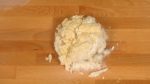Limpe a espátula com um raspador e coloque a mistura de farinha em um tábua para massas. Reúna os fragmentos da  mistura de farinha e forme em uma bola. Brevemente sove-a com as mãos.