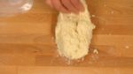 Jetez la pâte sur le plan de travail, Rassemblez-la, et jetez-la à nouveau. Rassemblez la pâte avec la corne à pâtisserie. Pétrissez la pâte avec vos mains en utilisant votre poids. Recommencez ces opérations jusqu'à ce que la pâte soit moins collante. 