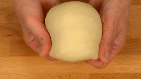 Like shown before, continue to throw the dough on the board. Knead the dough on the board and throw again. Repeat this throwing and rolling process for 10 minutes. The dough is now smooth and glossy.