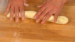 Saupoudrez la farine à pain sur le plan de travail et posez la pâte. Aplatissez la pâte et retirez le gaz dedans. Formez un long cylindre. Divisez la pâte en 5 morceaux égaux. Vérifiez qu'ils font tous le même poids. 
