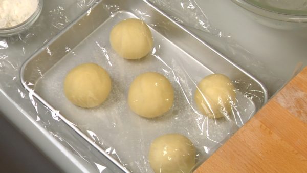 Spread the dough toward the other side of the cutting surface. Shape each dough piece into a ball. Make sure the bottom is tightly closed. Line up the dough balls on the cooking tray dusted with flour. Cover with plastic wrap and let them rest for 20 minutes at a room temperature.