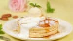 Sprinkle on the diced almonds. Add a small amount of whipped cream. Finally, garnish with the mint leaves. Enjoy the pancakes with the maple syrup.
