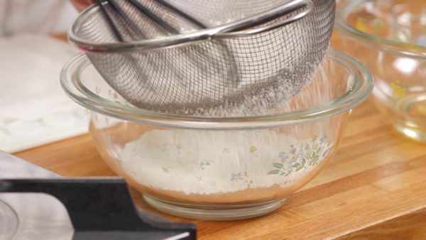 Let’s make the batter. Combine the cake flour and the baking powder and mix it with a balloon whisk. Then, sieve the flour into a bowl with a mesh strainer.