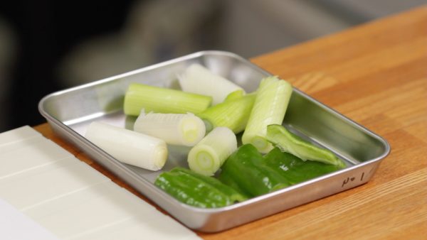 Make numerous cuts along the long green onion diagonally. The small cuts will help it to absorb the flavor and also help soften the texture. Then, cut the onion into 4cm (1.6") pieces. As for the bell pepper, cut it the same size as the onion.
