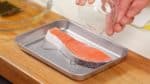 Préparez le saumon yakizuke. Arrosez le saumon avec le saké. Et étalez-le sur les deux côtés uniformément. 