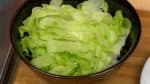 Machen wir das Rindersteak-Donburi. Den Salat auf eine Schale heißen gedämpften Reis geben. Zwiebel und Pilze am Rand der Schale verteilen