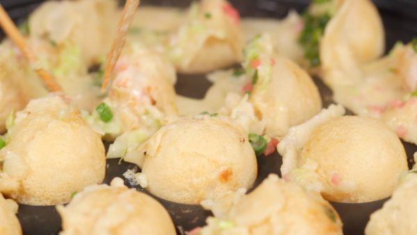 Girar el takoyaki poco a poco y darles forma de bolas.