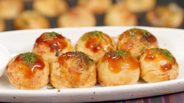 Spennellali con della salsa okonomiyaki. E cospargetevi incima delle alghe aonori. Infine, guarnire con i fiocchi di palamita. Potete anche completare il piatto con della maionese a piacere.