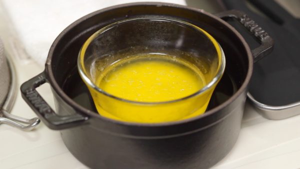 Campur mentega tawar dan susu dalam cangkir dan secara bertahap lelehkan dengan air panas.