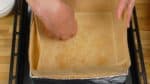 Letakkan kertas kraft atau kertas roti di dalam kotak karton yang dilapisi aluminium foil dan taburi gula pasir demerara atau gula kopi kristal.