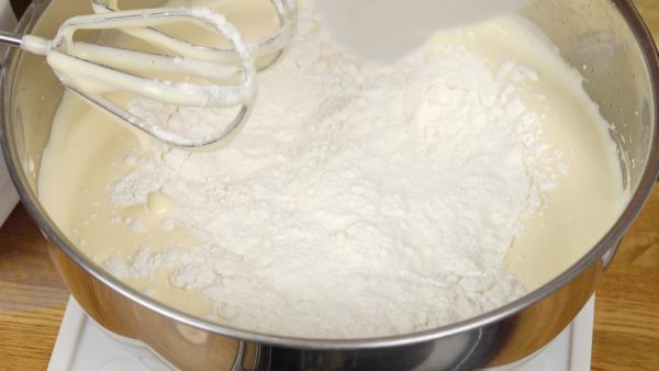 Distribua a farinha para pão na mistura de ovo. Em velocidade média, bata a mistura por cerca de 2 minutos até que fique com uma textura lisa novamente.