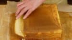 Saatnya menyajikan castella. Kupas kertas kraft / kertas roti dan potong tepi-tepi kue. Pada tiap irisan, seka pisau dengan lap bersih yang lembab untuk membuat potongan yang rapi.