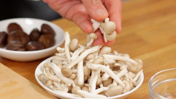 Meanwhile, let's prepare the ingredients. Coarsely chop the rehydrated shrimp into smaller pieces. As for the shimeji mushrooms, remove the stem ends and tear them into individual pieces.