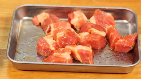 Coupez l'épaule de porc en cubes d'1 cm (0.4 inch) et versez le sake et la sauce soja dessus. Malaxez bien le porc avec l'assaisonnement jusqu'à ce que tout le liquide soit absorbé. 