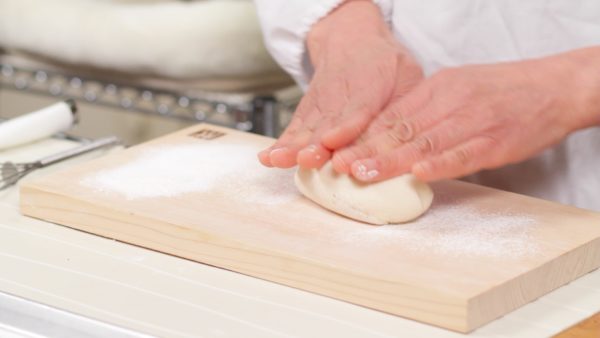 Press the flour with your hand to combine the dough. Then, place it onto a flat surface dusted with flour and knead the dough until it has a smooth texture.
