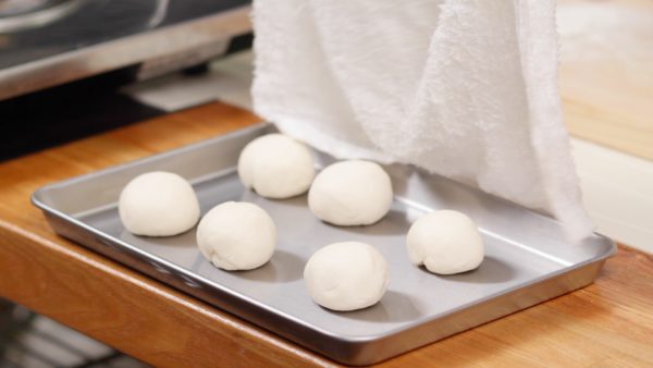Formez chaque morceau en boule. Couvrez la pâte avec un torchon mouillé et laissez-la reposer 30 minutes à température ambiante. 