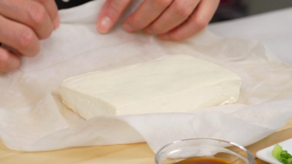 Heat the tofu in a microwave at 600 watts for 1 minute to remove the excess liquid. Unwrap the firm tofu and thoroughly remove the excess water with another paper towel.